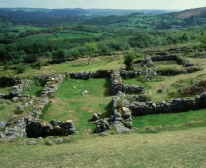 The low remaining walls of Hound Tor village on Dartmoor with a view across the valley.
